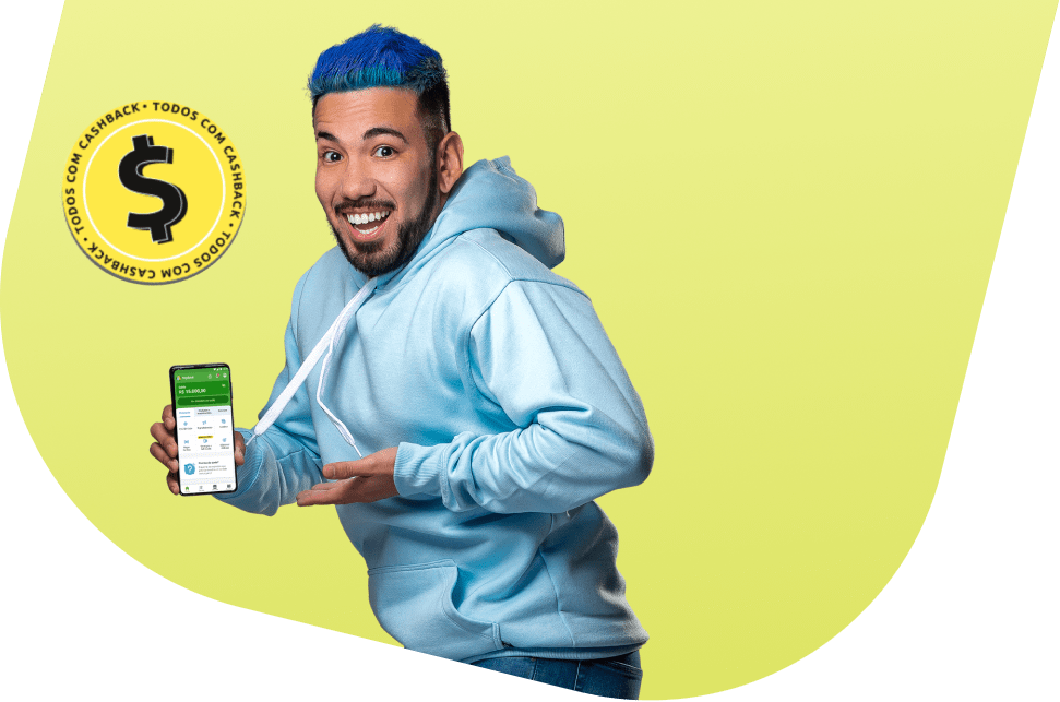 Homem branco, de cabelo azul, barba e expressão sorridente. Ele está vestindo um moletom azul claro e segurando um celular com o aplicativo PagBank aberto. Sobre a imagem há o selo 'todos com cashback'.