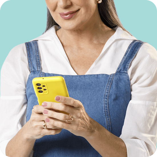 Mulher branca com celular amarelo em mãos, simbolizando o controle financeiro e a gestão de vendas com o app PagVendas do PagBank.