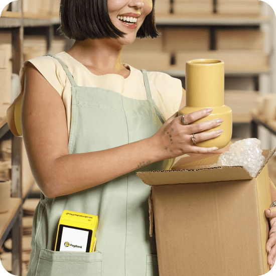 Empreendedora com Moderninha Pro 2 no bolso do avental, simbolizando a liberdade de antecipar vendas com qualquer maquininha pelo PagBank.