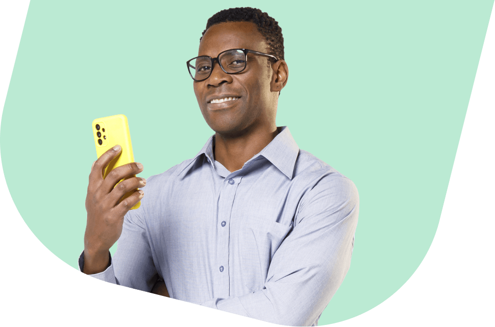 Homem preto sorridente segura um celular amarelo, simbolizando praticidade e controle nos investimentos com o PagBank.
