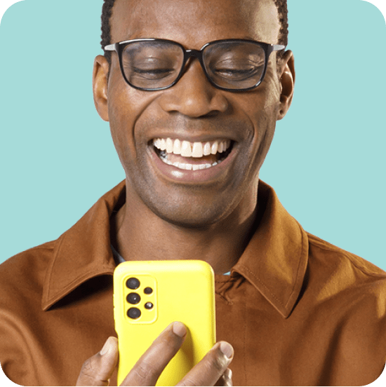 Homem preto sorridente segura um celular amarelo, representando praticidade e confiança na contratação do Empréstimo Consignado SIAPE.