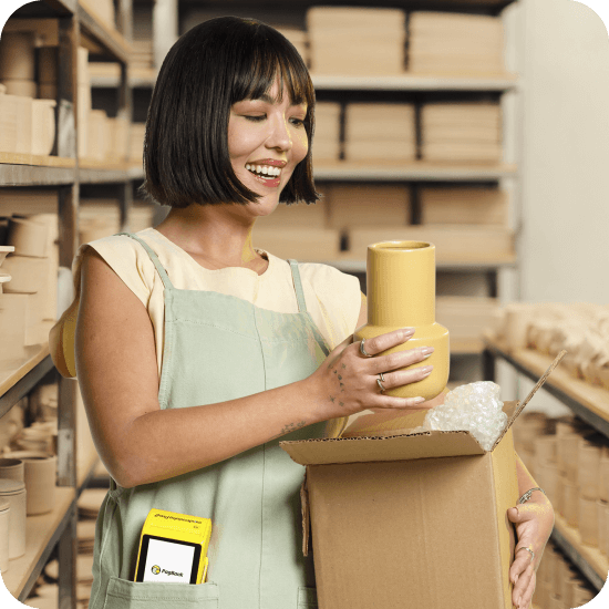 Mulher branca com Moderninha Pro 2 no bolso do avental, simbolizando as soluções completas de pagamento físico e online do PagBank.