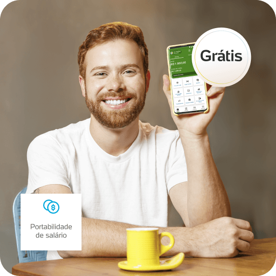 Homem branco sorridente segura um celular com o app do PagBank aberto, transmitindo praticidade e controle ao trazer o salário para o PagBank.