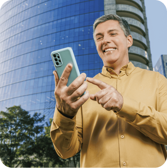 Homem branco sorridente segura um celular azul, transmitindo sensação de praticidade e confiança na contratação do Empréstimo Consignado SIAPE.