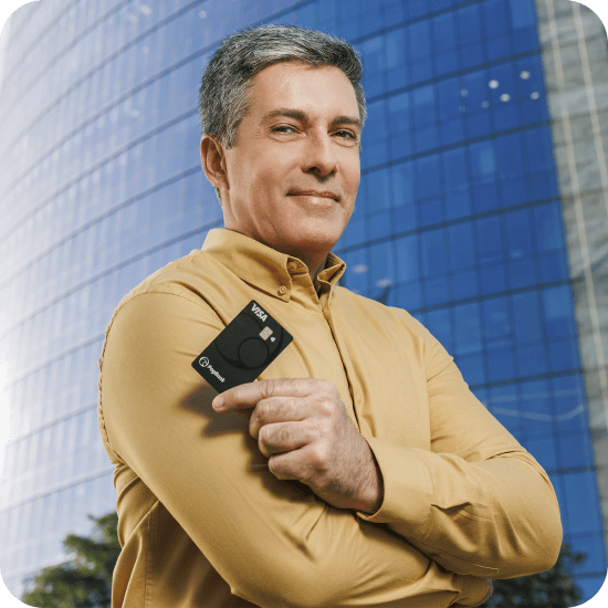 Homem branco segura um cartão PagBank com expressão tranquila, representando a proteção do cartão e de objetos pessoais oferecida pelo Seguro Cartão PagBank.