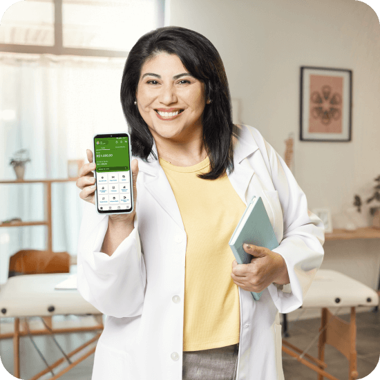 Mulher vestindo jaleco branco segura um celular com o aplicativo do PagBank aberto, em ambiente profissional com mesa de exame ao fundo. A imagem representa o uso do sistema de cobrança recorrente do PagBank para facilitar a gestão de vendas e recebimentos em negócios como consultórios e serviços.