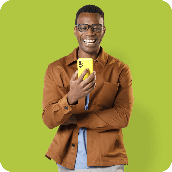 Homem preto segura um celular amarelo com o app PagBank aberto, representando praticidade para investir com carteiras recomendadas, controle financeiro e autonomia pelo aplicativo.