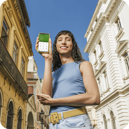 Mulher branca segura um celular com o aplicativo PagBank aberto, representando praticidade e proteção oferecida pelo Seguro Conta PagBank.